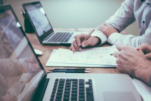 Mężczyźni przy laptopach i dokumentach